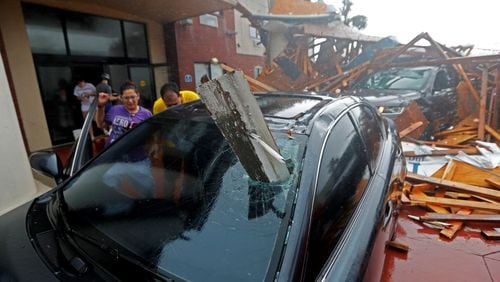 A woman checks on her vehicle as Hurricane Michael passes through, after the hotel canopy had just collapsed, in Panama City Beach, Fla., Wednesday. (AP Photo/Gerald Herbert)