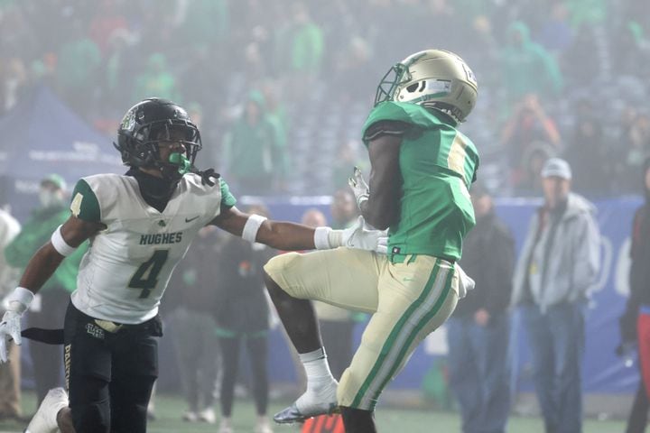 Buford wide receiver Tobi Olawole (4) catches the go-ahead touchdown against Langston Hughes defensive back Lataj Wright (4) during the fourth quarter of the Class 6A state title football game at Georgia State Center Parc Stadium Friday, December 10, 2021, Atlanta. JASON GETZ FOR THE ATLANTA JOURNAL-CONSTITUTION