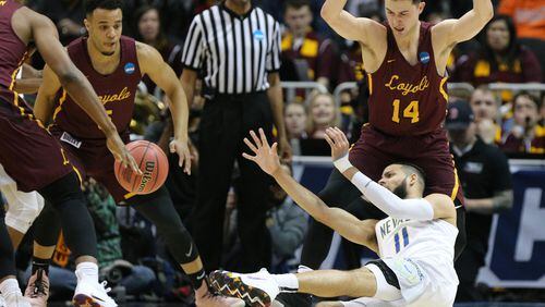 Nevada forward Cody Martin passes off under pressure from Loyola defender Ben Richardson during the first half of a regional semifinal NCAA college basketball game on Thursday in Atlanta.