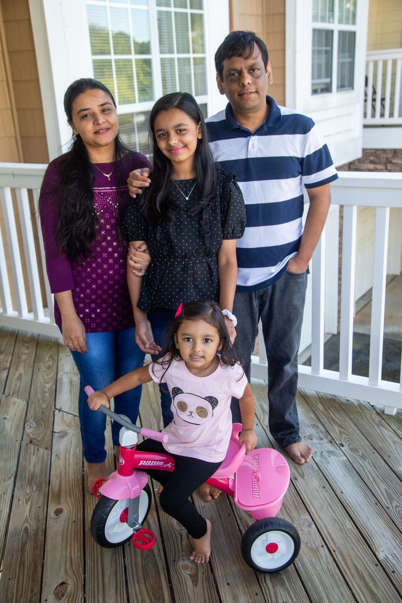 Hita Bhatt (clockwise from left) with her daughter Aesha (age 11), husband Mehul and daughter Hrisha (3) at their Johns Creek home. 
PHIL SKINNER FOR THE ATLANTA JOURNAL-CONSTITUTION.