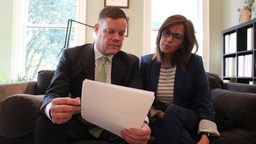 Nilsa Algarin Nieves and her attorney, Craig Kuglar, look over documents involving a hedge fund under scrutiny from federal authorities. Nieves and her husband, Edgard Nieves, have filed a lawsuit against the fund and its managers, saying investors had suffered millions of dollars in damages.