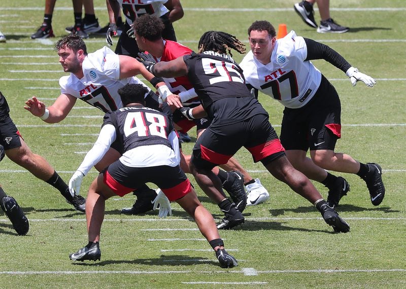 Falcons rookie offensive lineman Drew Dalman (left) and Jalen Mayfield (right) run block on a play during rookie minicamp Friday, May 14, 2021, in Flowery Branch. (Curtis Compton / Curtis.Compton@ajc.com)