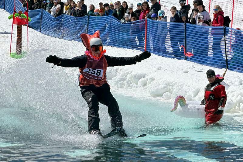 A skier participates in a pond skimming event at Gunstock Mountain Resort, Sunday, April 7, 2024, in Gilford, N.H. The wacky spring tradition is happening this month at ski resorts across the country and is often held to celebrate the last day of the skiing season. (AP Photo/Nick Perry)
