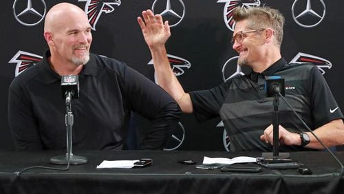 Falcons coach Dan Quinn and general manager Thomas Dimitroff, who both just signed contract extentions, share a laugh during their news conference about wide receiver Julio Jones on the day players report to training camp on Thursday, July 26, 2018, in Flowery Branch. Curtis Compton/ccompton@ajc.com