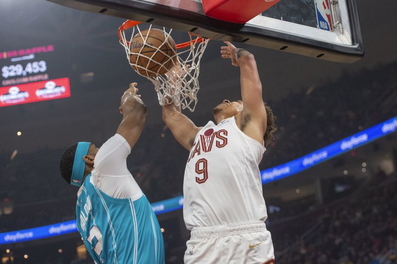 Cleveland Cavaliers' Craig Porter Jr. (9) dunks over Charlotte Hornets' Marques Bolden, left, during the first half of an NBA basketball game in Cleveland, Sunday, April 14, 2024. (AP Photo/Phil Long)