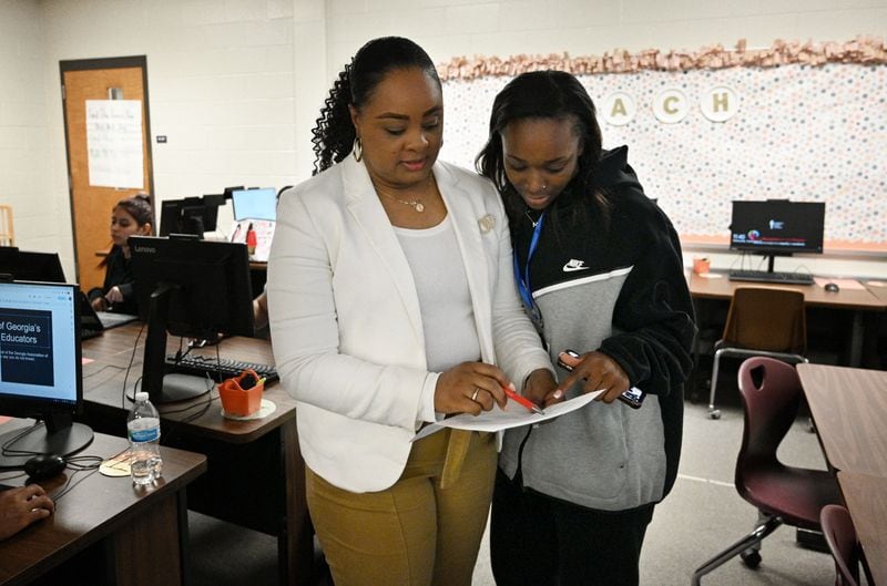 Y'Shakaa Durham (left), a career and technical education teacher, confers with Alijah Gabriel, a senior student and teacher intern, at South Gwinnett High School on Sept. 13, 2023. Durham teaches classes about education as part of Gwinnett's Teaching as a Profession pathway. Students are interested in teaching and get a deeper exposure to the career. (Hyosub Shin / Hyosub.Shin@ajc.com)