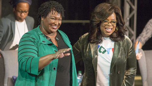 Oprah Winfrey and Stacey Abrams greet a crowd gathered for a town hall conversation at the Cobb Civic Center on Nov. 1, 2018.