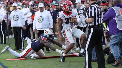 The moment before Georgia running back Brian Herrien collides with photographer Chamberlain Smith on the sidelines Saturday, Nov. 16, 2019, at Jordan-Hare Stadium in Auburn, Ala. The intern for the UGA Athletic Association was knocked unconscious for a brief time and suffered a black eye.