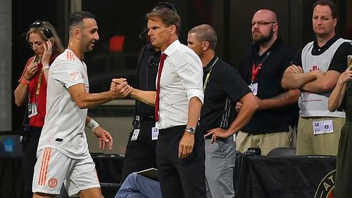 Atlanta United's Justin Meram (14) is congratulated by head coach Frank de Boer (right) after being subbed off against the Montreal Impact June 29, 2019, at Mercedes Benz Stadium in Atlanta.