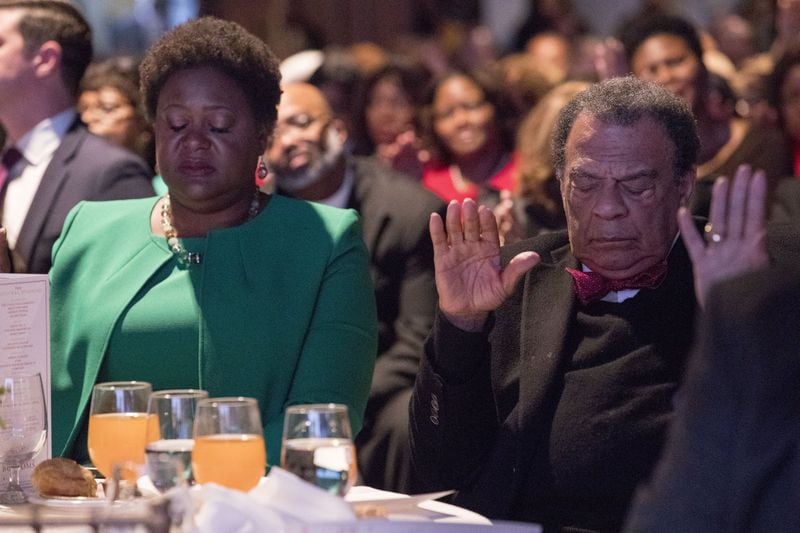 Atlanta City Council President  Felicia Moore and former Atlanta Mayor Andrew Young bow their heads prayer during an interfaith worship service on January 2, 2018, at Impact Church in East Point. ALYSSA POINTER/alyssa.pointer@ajc.com