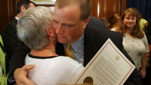 ATLANTA, GA -- Former Olympic security guard Richard Jewell hugs his mother Barbara as his wife Dana , at right, looks on Tuesday afternoon, August 1, 2006 after he received a commendation from Gov. Sonny Perdue for his service during the Olympics. (BEN GRAY/AJC staff)