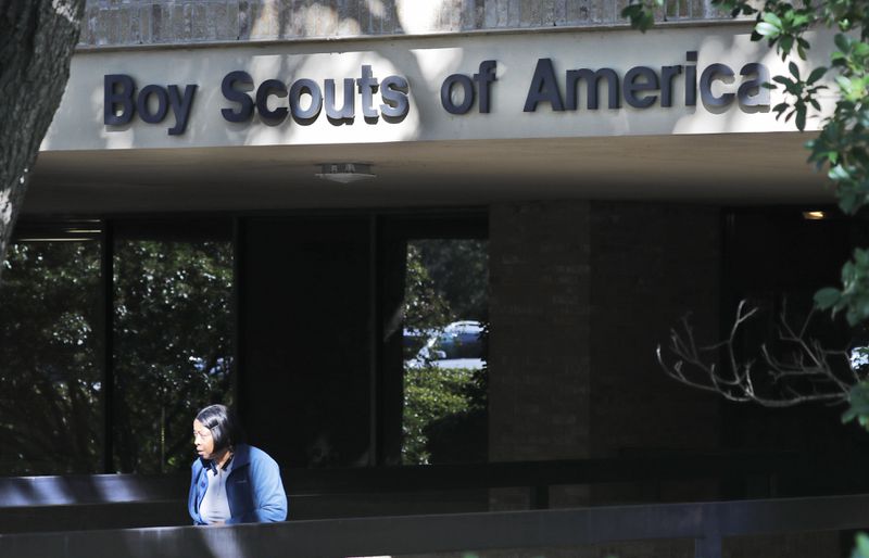 FILE - A woman walks out of the Boy Scouts of America national headquarters building in Irving, Texas, Nov. 1, 2019. The U.S. organization, which now welcomes girls into the program and allows them to work toward the coveted Eagle Scout rank, announced Tuesday, May 7, 2024, that it will change its name to Scouting America as it focuses on inclusion. (AP Photo/LM Otero, File)