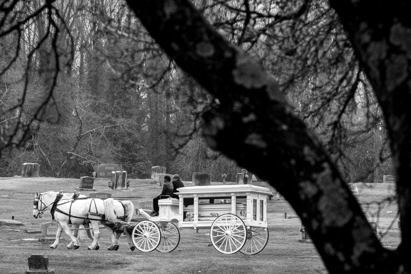 A horse-drawn carriage takes the body of Betty Lue Surry through Lincoln Cemetery in Atlanta. 