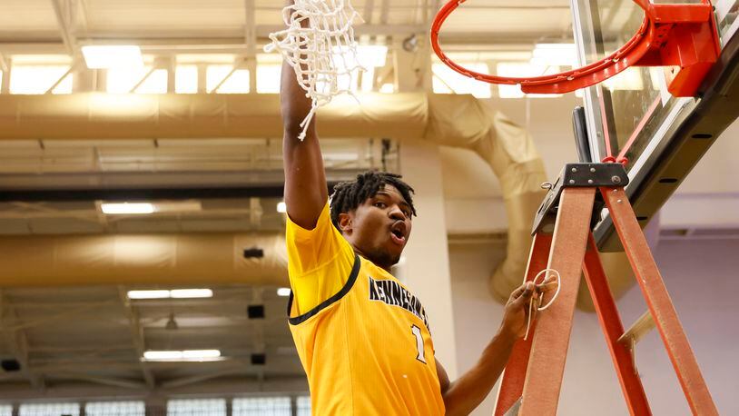 Kennesaw State guard Terrell Burden cuts down the net after the Owls won the ASUN Championship title Sunday. (Miguel Martinez /miguel.martinezjimenez@ajc.com)