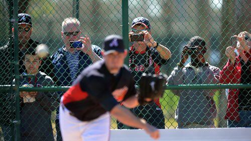 Braves fans snap pictures of Braves closer Craig Kimbrel as he works on his delivery.