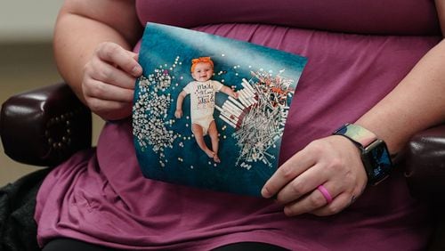 Elizabeth Goldman, an in-vitro fertilization patient at the University of Alabama at Birmingham, holds up a photo of her daughter who was born via the procedure. (ELIJAH NOUVELAGE/GETTY IMAGES)