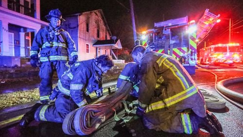 A firefighter was injured battling a house fire Friday at the corner of Mayson Turner Road and Joseph E. Lowery Boulevard. JOHN SPINK / JSPINK@AJC.COM