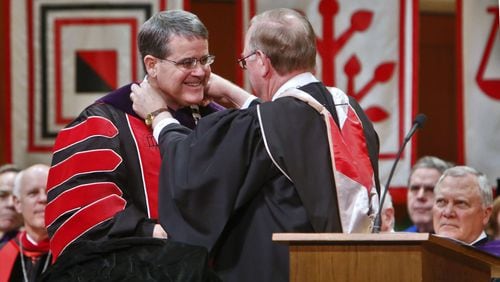 At the investiture ceremony of University of Georgia President Jere W. Morehead (left) Tuesday in Athens, the vestment, or chain of office, was placed on him by Hank Huckaby (right), chancellor of the University System of Georgia. BOB ANDRES / BANDRES@AJC.COM