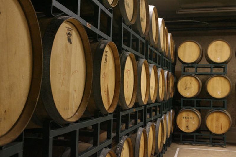 Oak barrels, used to age wine, line the walls of the winery's cask room.