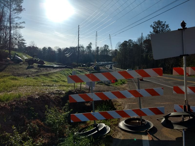 This section of Arnold Mill Road has been blocked to traffic so that work can begin on the road sections leading to the new bridge. This photo is west of the bridge on the Cherokee County side. The bridge construction can be seen near the far left of the photo.