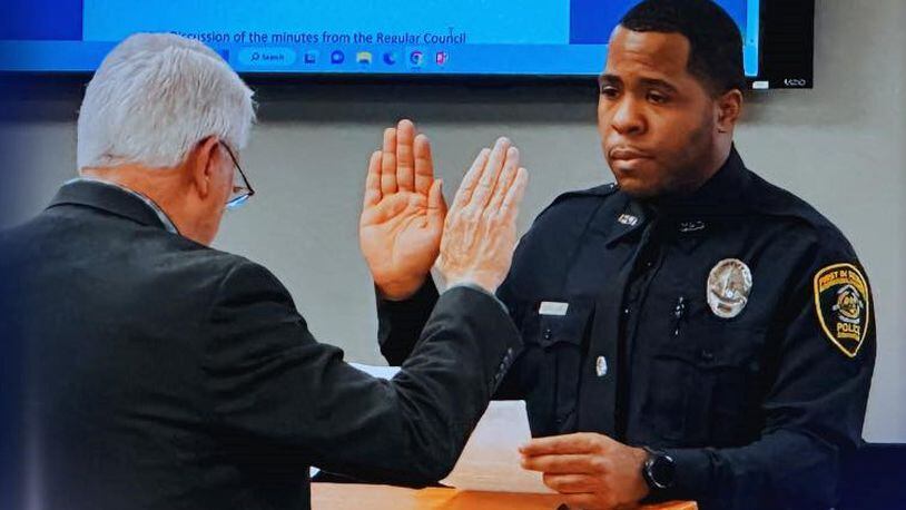 Rashad Rivers (right) is sworn in as an officer of the Covington Police Department in a January ceremony. He was wounded in a shooting Tuesday night at a motel.