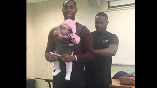 Morehouse College visiting professor Nathan Alexander volunteered to watch the child he's holding when his student, Wayne Hayer, right, could not find childcare before Alexander's class on Friday, March 1, 2019. PHOTO CONTRIBUTED.