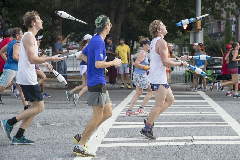 A group of juggling men participate during the 49th running of the AJC Peachtree Road Race near Piedmont Park, Wednesday, July 4, 2018.  ALYSSA POINTER/ALYSSA.POINTER@AJC.COM