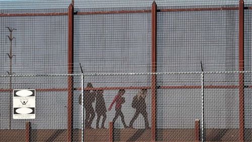 Migrants walk together along the U.S./Mexican border wall as they look to turn themselves over to the U.S. Border Patrol as they seek asylum in the United States on June 04, 2019 in El Paso, Texas. (Photo by Joe Raedle/Getty Images)