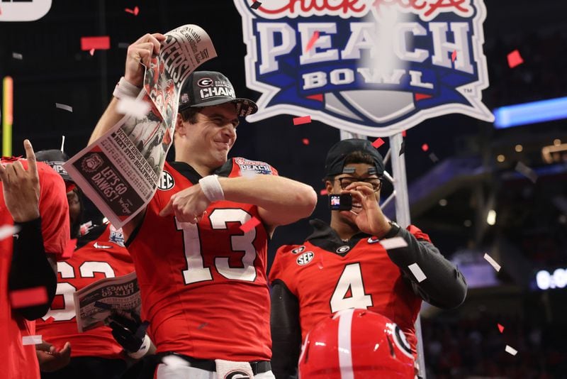 Georgia quarterback Stetson Bennett (13) celebrates their 42-41 win against Ohio State in the Peach Bowl Playoff Semifinal, at Mercedes-Benz Stadium, Sat., Dec. 31, 2022, in Atlanta. State lawmakers are adjusting the beginning of this year's legislative session due to the college championship game. (Jason Getz/The Atlanta Journal-Constitution)