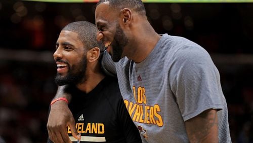Kyrie Irving and LeBron James of the Cleveland Cavaliers laugh during a game against the Miami Heat.