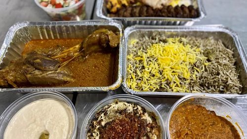 This takeout feast from Taaj Kabob & Grill includes: in the back, Shirazi salad and beef and chicken koobideh kebobs; in the middle, lamb shank and baghali polo; and up front, hummus, kashk badenjoon and mirza ghasemi. Wendell Brock for The Atlanta Journal-Constitution