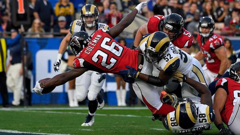  Falcons RB Tevin Coleman stretches for a touchdown while fighting off the tackle attempt of former UGA linebacker Alec Ogletree during Sunday's game against the Rams. (AP Photo/Mark J. Terrill )