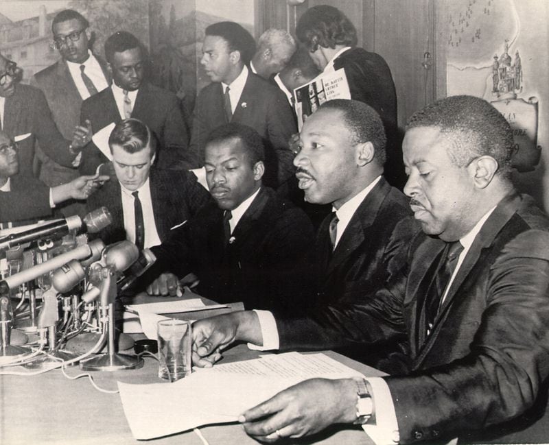 From a 1965 press conference, Martin Luther King Jr. (seated second from right) announced the first stage of a three-stage economic boycott of Alabama. King is flanked by the Reverend Ralph Abernathy on his right and John Lewis on his right. Andrew Young, a King aide, is standing behind Lewis. Photo taken on 4/2/65.  (PHOTO CREDIT AP)