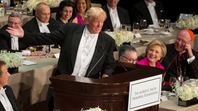 Hillary Clinton looks on as Donald Trump speaks at the annual Alfred E. Smith Memorial Foundation dinner at the Waldorf Astoria hotel in New York, Oct. 20, 2016. A day after their final presidential debate, Trump joked that the event was ?the first time Hillary is sitting down and speaking to major corporate leaders and not getting paid for it.? (Ruth Fremson/The New York Times)