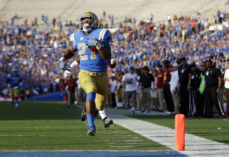 UCLA running back Joshua Kelley (27) scores a rushing touchdown against Southern California during the second half of an NCAA college football game Saturday, Nov. 17, 2018, in Pasadena, Calif. (AP Photo/Marcio Jose Sanchez)