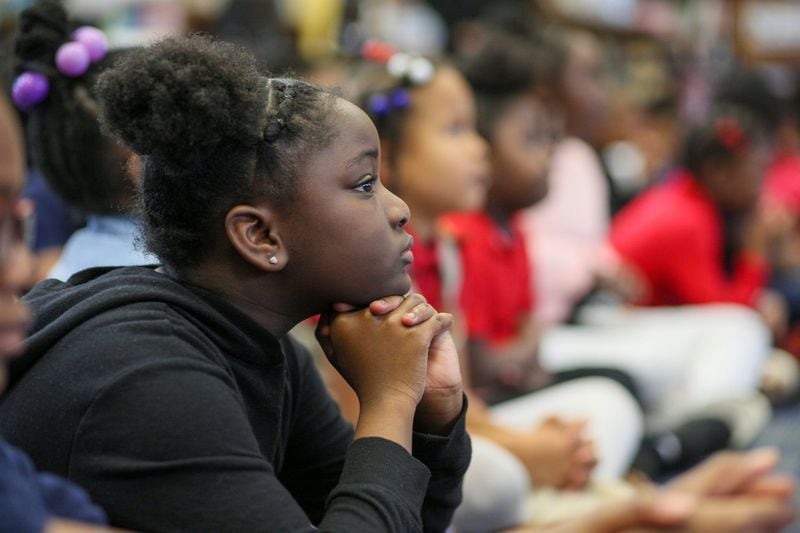 Second-grader Aniyah Usher listens to a famous athlete of the 1968 Mexico Olympic Games, John Carlos, talk at Barack H. Obama Elementary Magnet School of Technology on Wednesday, Feb. 26, 2020, in Atlanta. (Photo: MIGUEL MARTINEZ for the AJC)