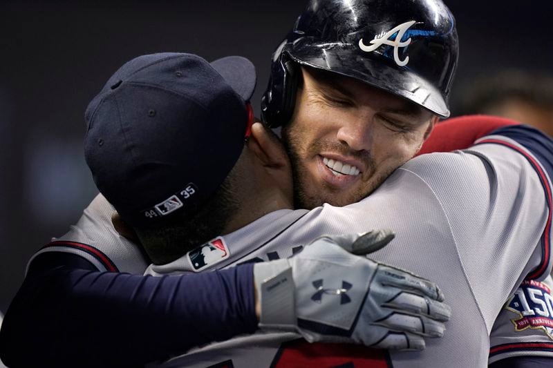 Atlanta Braves' Freddie Freeman gets a hug from Pablo Sandoval after Freeman hit a home run during the first inning of the team's baseball game against the Miami Marlins, Friday, July 9, 2021, in Miami. (AP Photo/Wilfredo Lee)