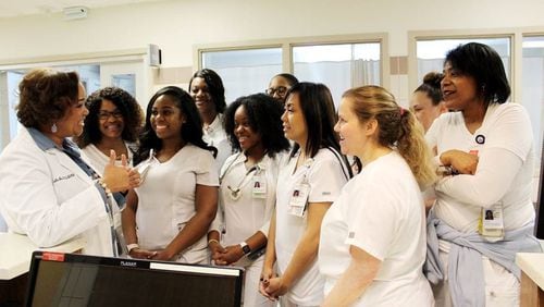 Jacqueline Herd (left), chief nursing officer at Grady Memorial Hospital, holds an informal briefing with nurses in the hospital’s intensive care unit. CONTRIBUTED