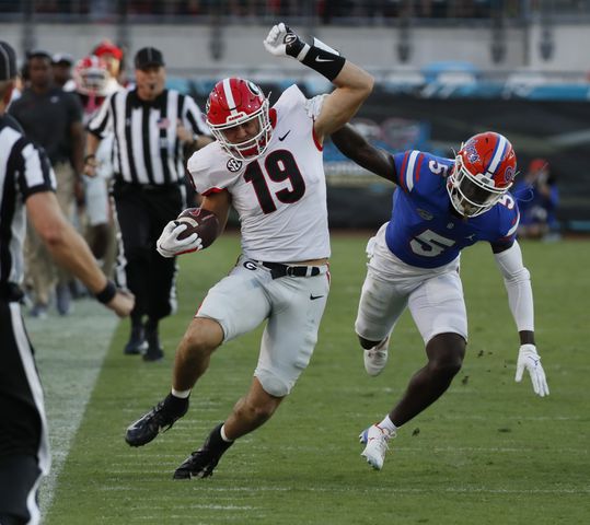 10/30/21 - Jacksonville -  Georgia Bulldogs tight end Brock Bowers (19) stretches a catch for a long first down, with  Florida Gators cornerback Kaiir Elam (5) defending, during the second half of the annual NCCA  Georgia vs Florida game at TIAA Bank Field in Jacksonville. Georgia won 34-7.  Bob Andres / bandres@ajc.com