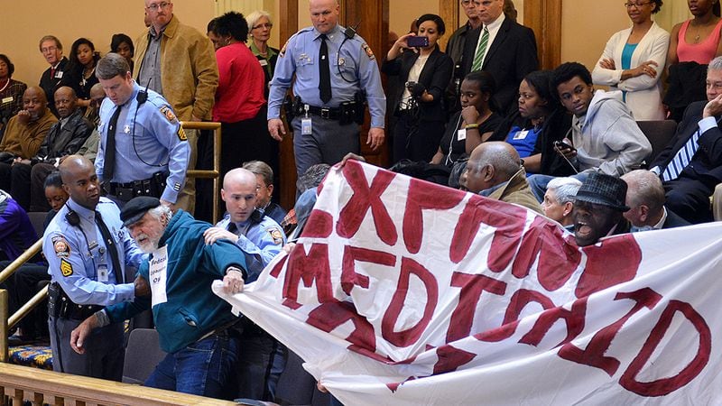 About 20 Moral Monday protesters were arrested at the state Capitol after disrupting the Senate by shouting and holding signs calling for Medicaid expansion on Tuesday March 18, 2014.  BRANT SANDERLIN / AJC FILE PHOTO