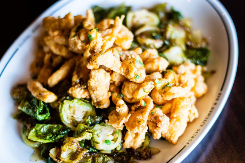 The Public Kitchen & Bar, which also has a location in Savannah, serves fried gator bites on top of a bed of Brussels sprouts. CONTRIBUTED BY HENRI HOLLIS