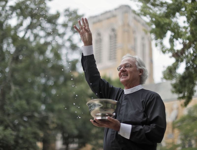 For a couple of decades, Rev. Samuel Candler of the The Cathedral of St. Philip blesses AJC Peachtree Road Race runners with holy water. He’s doing the invocation at the start of this year’s race. Bob Andres / bandres@ajc.com
