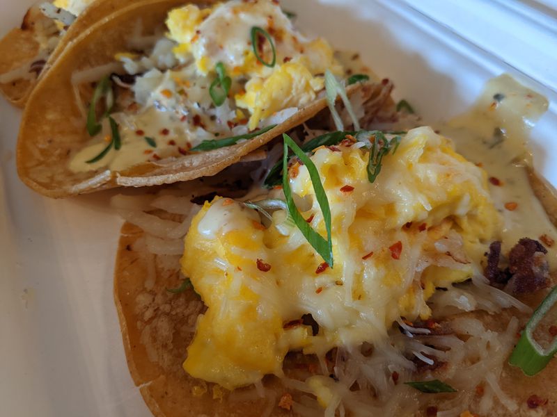 The breakfast tacos from Snooze combine a trio of corn tortillas filled with cage-free scrambled eggs, hash browns, jack cheese, green chile hollandaise and pico de gallo. Courtesy of Paula Pontes