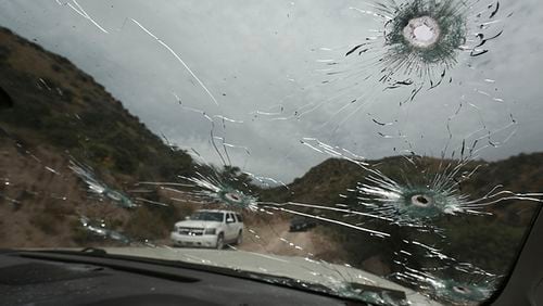 Bullet-riddled vehicles that members of the extended LeBaron family were traveling in sit parked on a dirt road near Bavispe, at the Sonora-Chihuahua state border, Mexico, on Wednesday. Three women and six of their children, related to the extended LeBaron family, were gunned down in an attack while traveling here Monday.