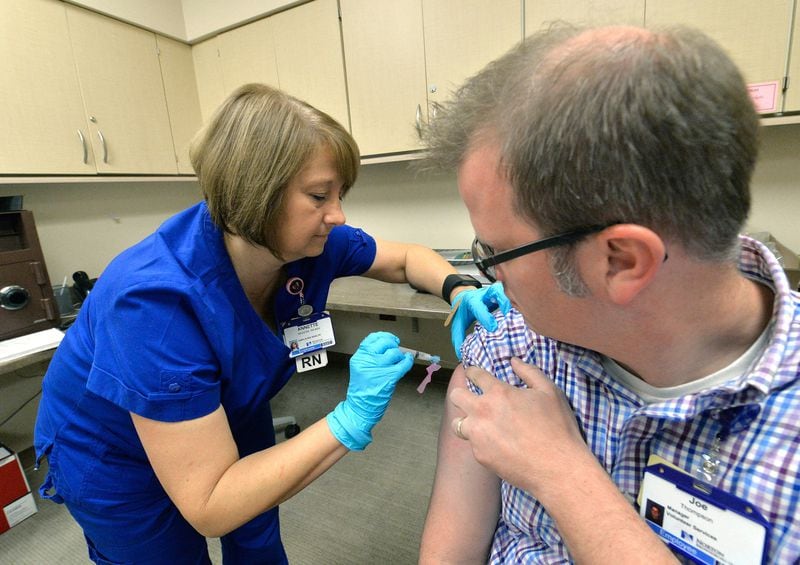 Annette Mazzoni, left, a nurse at the Norton Brownsboro Hospital, gives a flu shot to Joe Thompson Wednesday, Oct. 21, 2015, in Louisville, Ky.