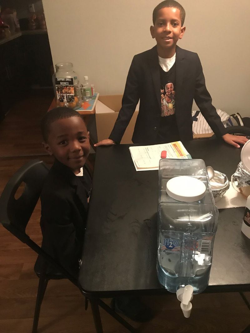 Ja’Den St. Hilaire (left), 7, and his brother Anthony Roberson, 10 are the owners of Brown Boys Lemonade. Here, they give a lemonade-making demonstration in their Doraville home. (Photo by Ligaya Figueras)