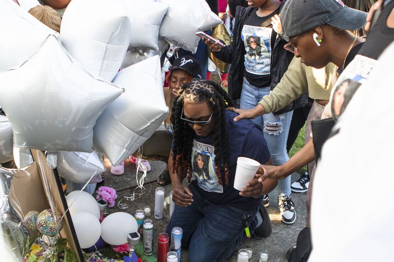 Akeyia Williams pays her respects during a candlelight vigil for Koko Da Doll on Saturday.