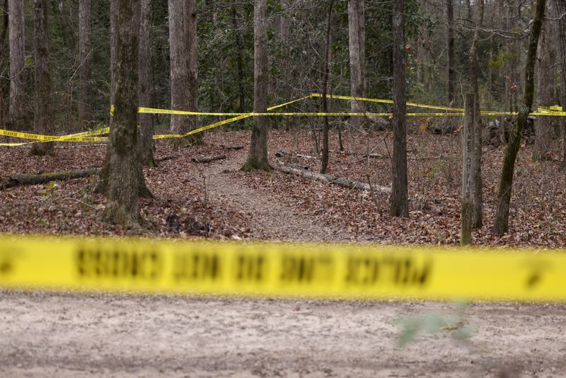 Police tape ropes off the crime scene on a trail behind Lake Herrick in Athens at the University of Georgia on Friday, Feb. 23, 2024. A female nursing student was found dead nearby on Thursday. (Jason Getz / jason.getz@ajc.com)