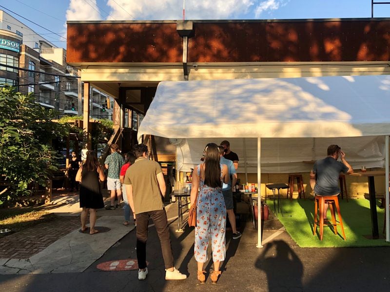 A Mano, at the corner of Ralph McGill Boulevard and Randolph Street, has put its bar outside, and added tents and tables, so customers can enjoy their takeout on the property. CONTRIBUTED BY WENDELL BROCK
