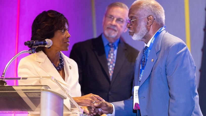 Morehouse School of Medicine President Dr. Valerie Montgomery Rice shakes hands with Dr. David Satcher, former surgeon general of the United States, during the inaugural Dr. David Satcher Global Health Equity Summit in Atlanta. Looking on is  Dr. Barney Graham, who received the first Dr. David Satcher Award for his decades-long efforts to advance equity in research, particularly in vaccine development.   September 14, 2023. (Arvin Temkar / arvin.temkar@ajc.com)